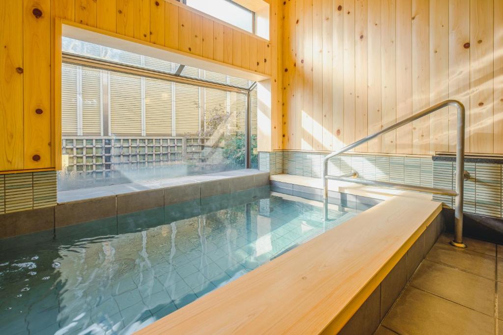 - une piscine avec banc dans un bâtiment en bois dans l'établissement Hamabe no Yado Asahiya, à Himi