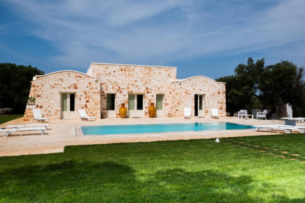 une maison en pierre avec une piscine en face de celle-ci dans l'établissement Casa Tonini, à Ostuni