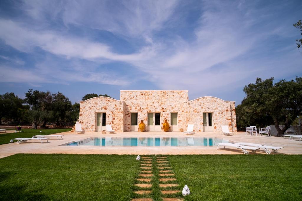 une maison en pierre avec une piscine dans la cour dans l'établissement Casa Tonini, à Ostuni