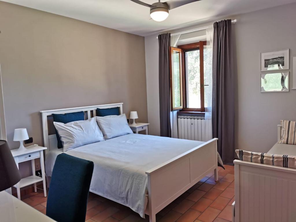 une chambre avec un lit blanc et une chaise bleue dans l'établissement Villa alla Torre - Homelike Villas, à San Severino Marche 31 autres photos