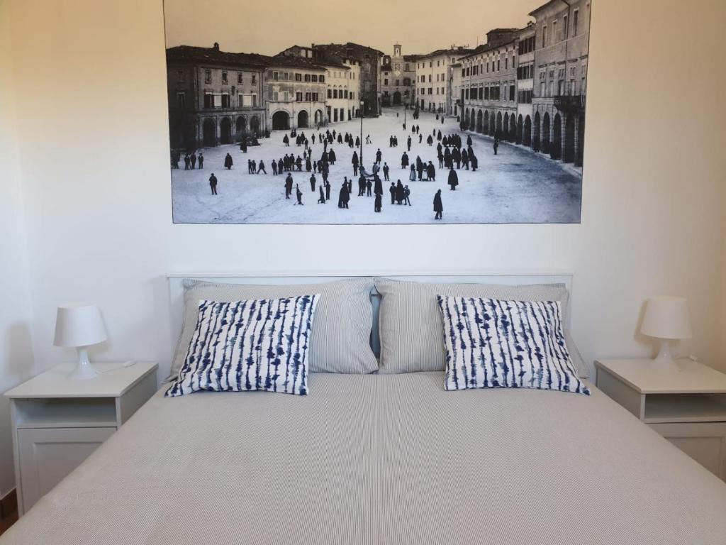 un lit avec deux oreillers et un tableau au mur dans l'établissement Villa alla Torre - Homelike Villas, à San Severino Marche