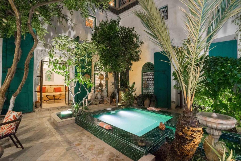 - une piscine dans une pièce ornée d'arbres et de plantes dans l'établissement Dar Kleta, à Marrakech