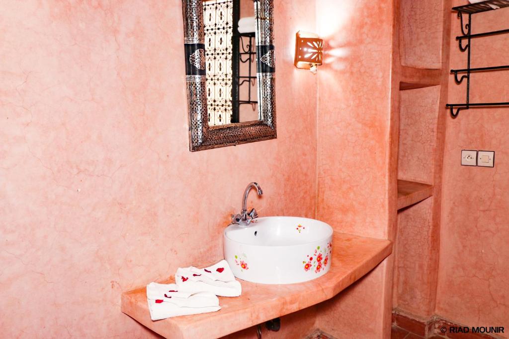 une salle de bain avec un lavabo et des serviettes sur un comptoir dans l'établissement Riad Mounir, à Marrakech