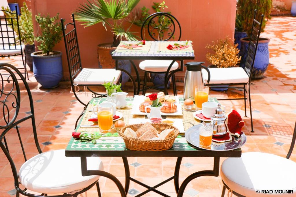 une table avec de la nourriture et des boissons sur une terrasse dans l'établissement Riad Mounir, à Marrakech