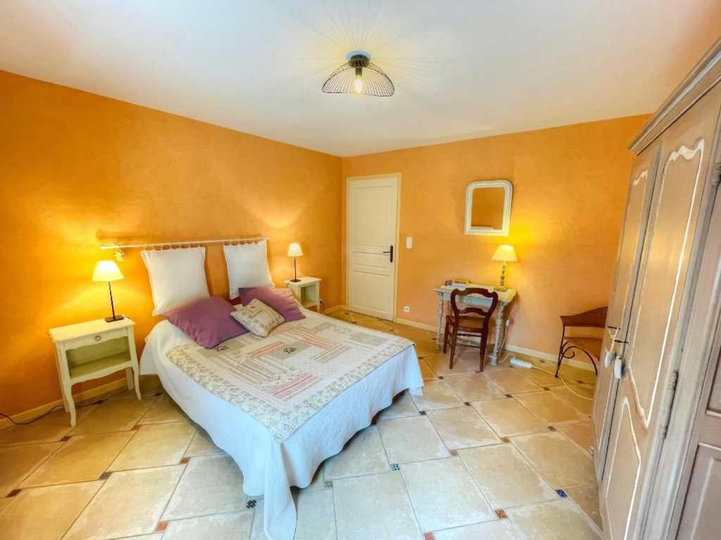 une chambre avec un grand lit et une table dans l'établissement Gîte de charme avec piscine couverte entre Châteaux de la Loire et Futuroscope - FR-1-381-520, à Draché 24 autres photos
