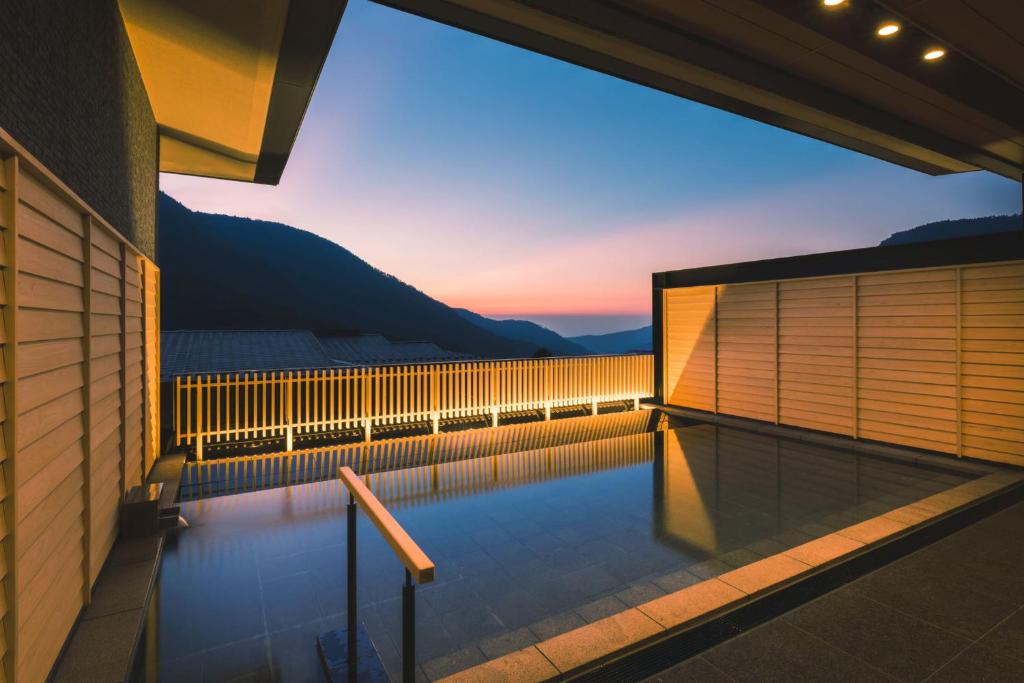 une piscine avec un coucher de soleil en arrière-plan dans l'établissement Hakone Gora KARAKU, à Hakone