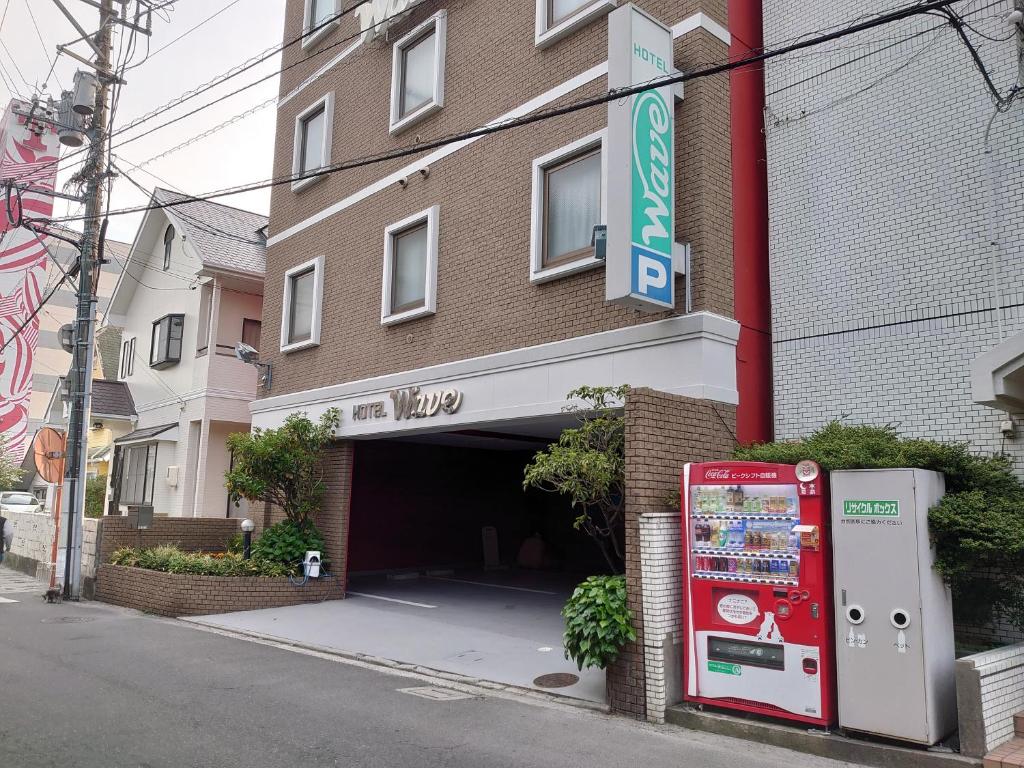 un bâtiment avec une machine à soda devant lui dans l'établissement Hotel Wave大人専用, à Hiroshima