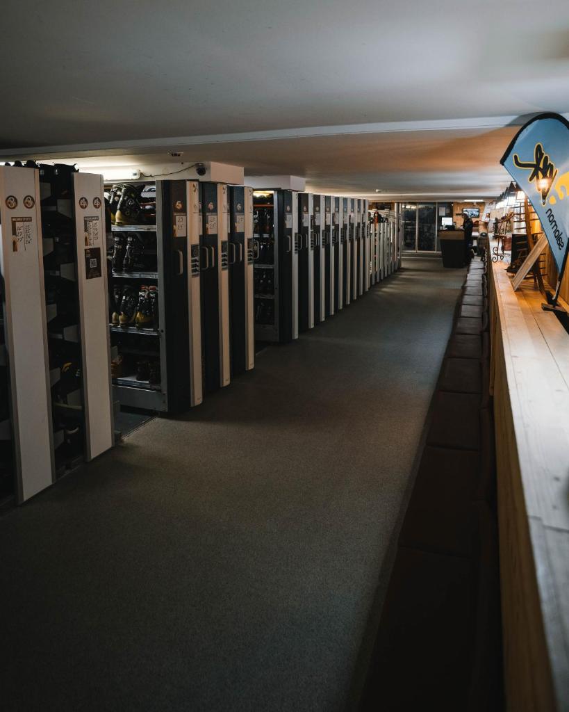 un long couloir avec des étagères de bouteilles de vin dans l'établissement Hôtel Aalborg, à Les Deux Alpes
