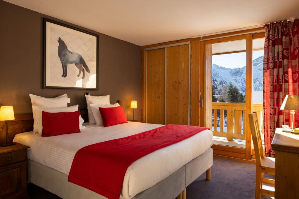 une chambre avec un lit et une grande fenêtre dans l'établissement Hôtel Aalborg, à Les Deux Alpes