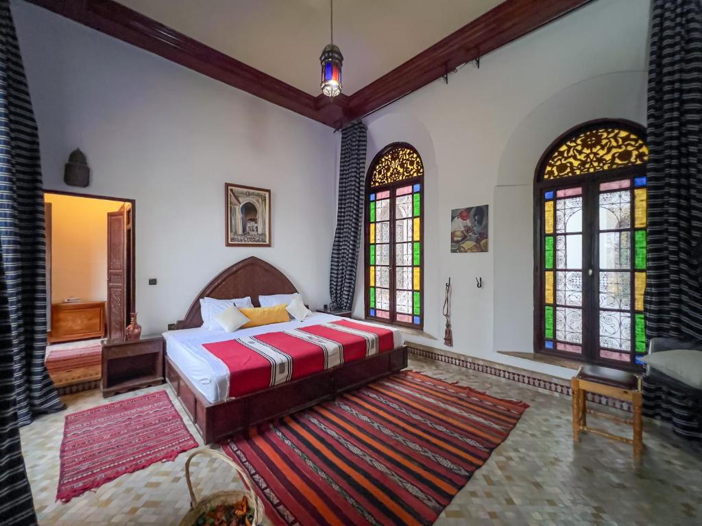 une chambre avec un lit et des vitraux dans l'établissement Riad Pacha Palace, à Fès 37 autres photos