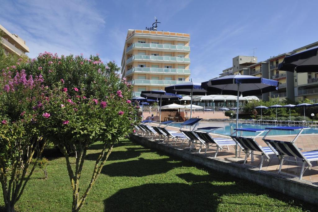 - une rangée de chaises et de parasols à côté de la piscine dans l'établissement Hotel Royal, à Bibione