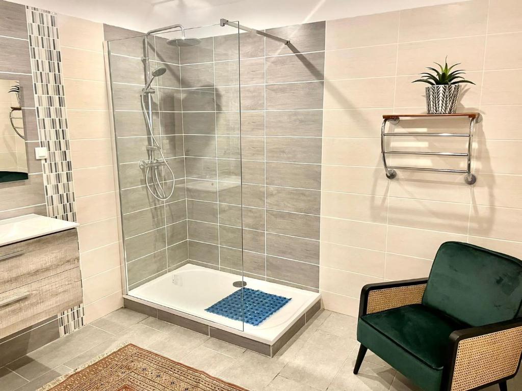 La salle de bains est pourvue d'une douche, d'une chaise et d'une baignoire. dans l'établissement Beautiful 1-Bed Gite 2km quiet walk from Eymet, à Eymet