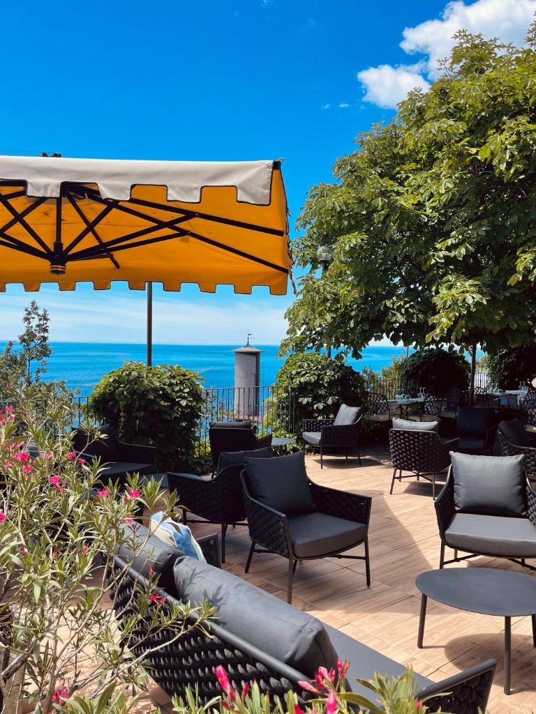 une terrasse avec des chaises et des parasols et l'océan dans l'établissement Hotel Riviera & Maximilian's, à Trieste 109 autres photos