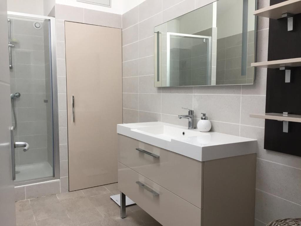 une salle de bain blanche avec un lavabo et une douche dans l'établissement Ski 3 Vallées à 80m télécabine de l'Olympe - appt 50m2, 3étoiles, à Brides-les-Bains