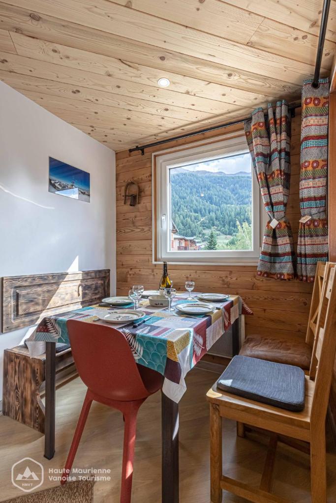 une salle à manger avec une table et une fenêtre dans l'établissement Roc de Burel, à Lanslevillard