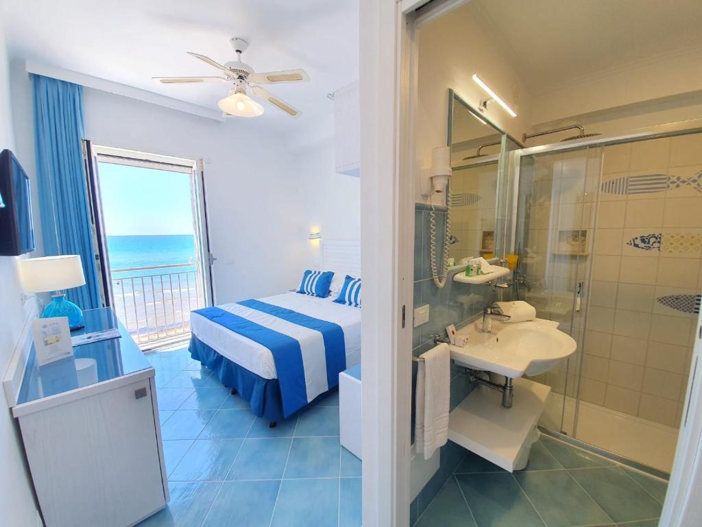 Cette chambre comprend un lit, un lavabo et une salle de bains. dans l'établissement Hotel Aurora, à Sperlonga