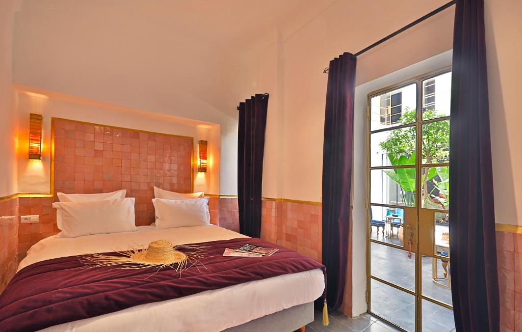 une chambre avec un lit et une grande fenêtre dans l'établissement Riad la Parenthèse by Sashema, à Marrakech