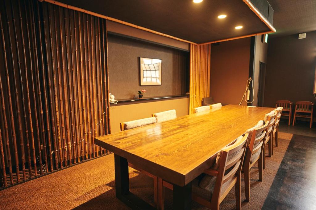 une salle de conférence avec une table et des chaises en bois dans l'établissement Nogami Honkan, à Beppu 37 autres photos