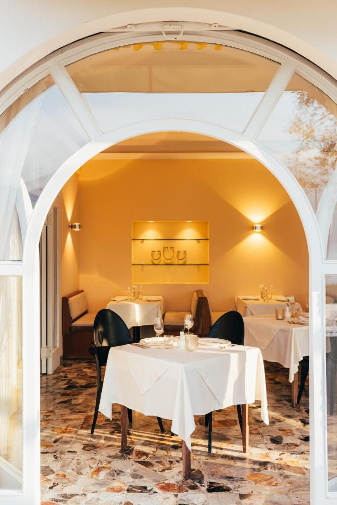 une salle à manger avec des tables et des chaises ainsi qu'une voûte dans l'établissement Hotel Orione - Lake Front Hotel, à Brenzone