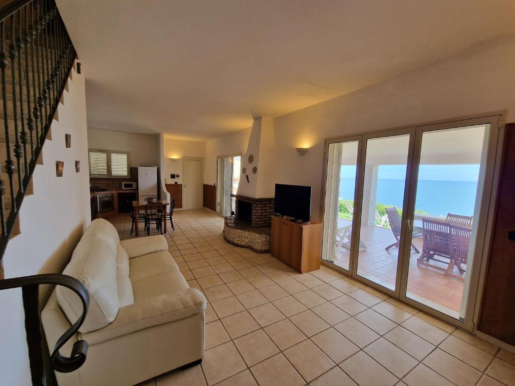 un salon avec un canapé et une vue sur l'océan dans l'établissement Villa Daniela - Villa con piscina privata e discesa a mare tra Catania e Siracusa, à Augusta