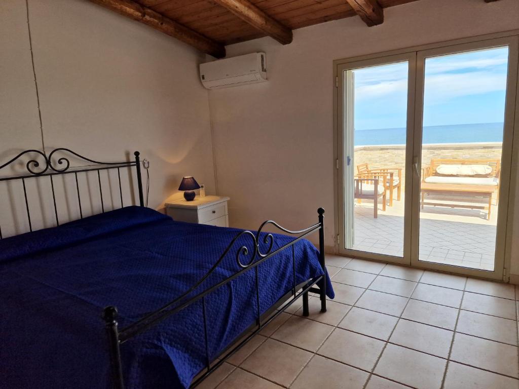 une chambre avec un lit et une vue sur l'océan dans l'établissement Villa Daniela - Villa con piscina privata e discesa a mare tra Catania e Siracusa, à Augusta