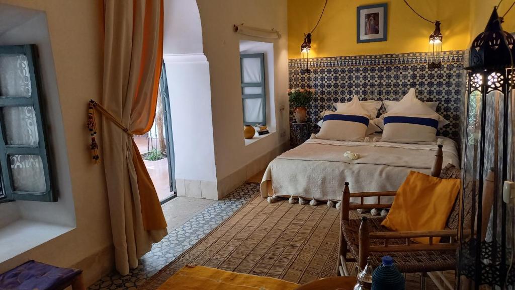une chambre avec un lit avec des oreillers bleus et blancs dans l'établissement Dar El Kharaz, à Marrakech