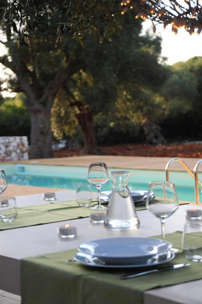 - une table avec un tissu de table vert et des verres à vin dans l'établissement Bosco degli Ulivi, à Morciano di Leuca