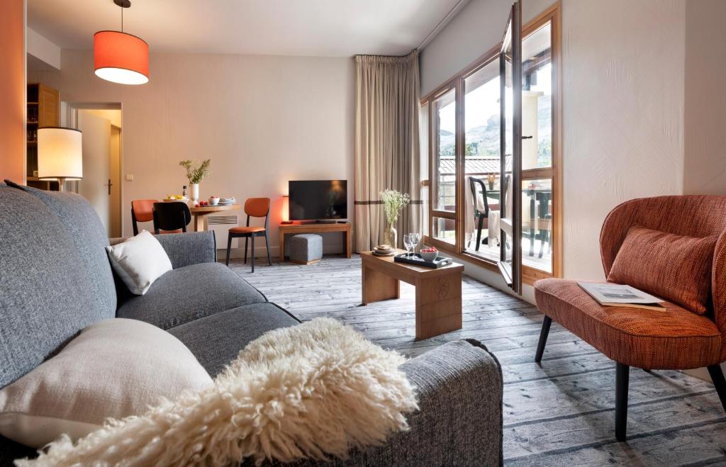 un salon avec un canapé et une table dans l'établissement Résidence Pierre & Vacances Premium Les Terrasses d'Eos, à Flaine