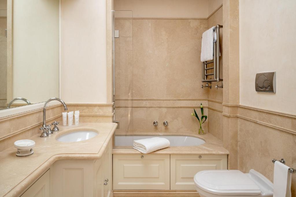une salle de bain avec un lavabo, des toilettes et un miroir dans l'établissement Luxury Villa Manin Viareggio | UNA Esperienze, à Viareggio