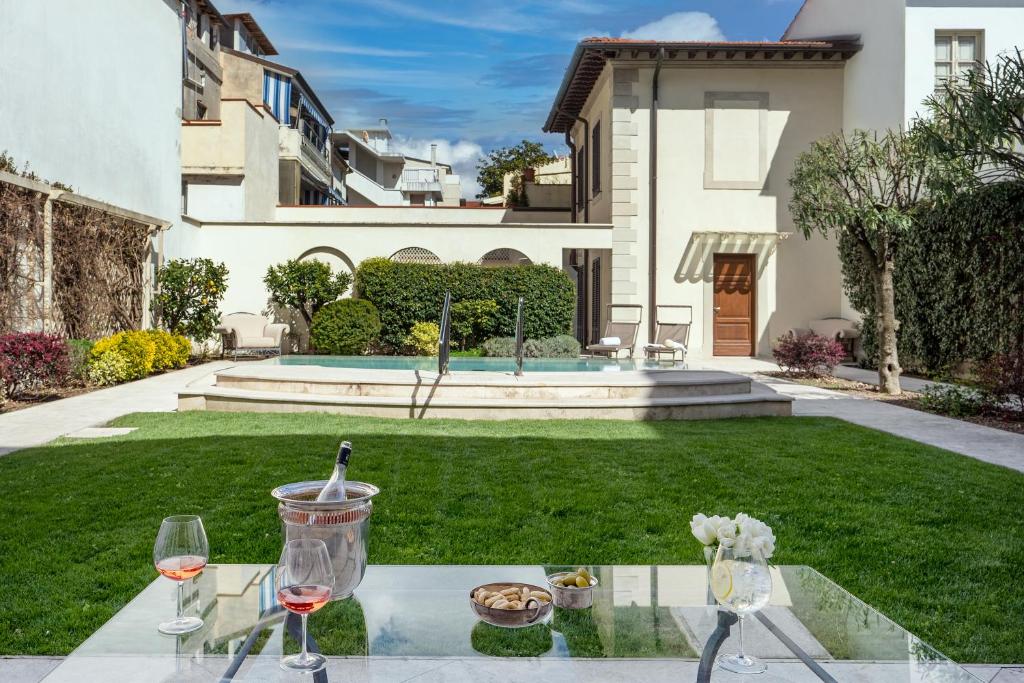- une table avec des verres de vin au-dessus d'une cour dans l'établissement Luxury Villa Manin Viareggio | UNA Esperienze, à Viareggio