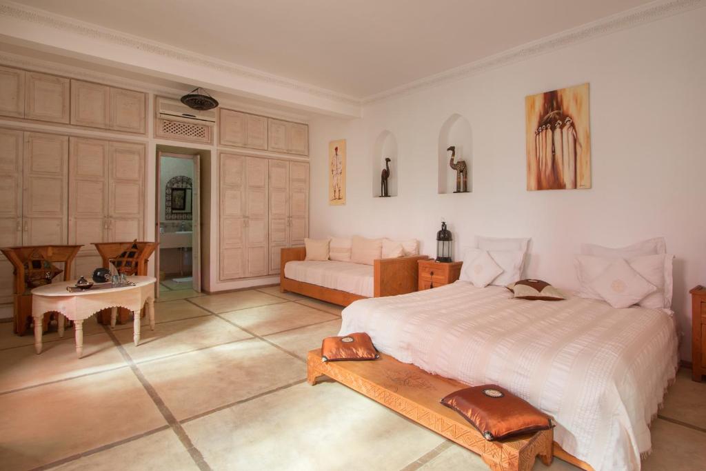 une chambre avec un lit, une table et un canapé dans l'établissement Riad Alegria, à Marrakech