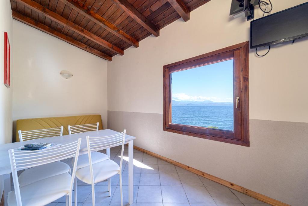 une salle à manger avec une table et une fenêtre dans l'établissement VILLA GARUTI VILLAGE, à Padenghe sul Garda