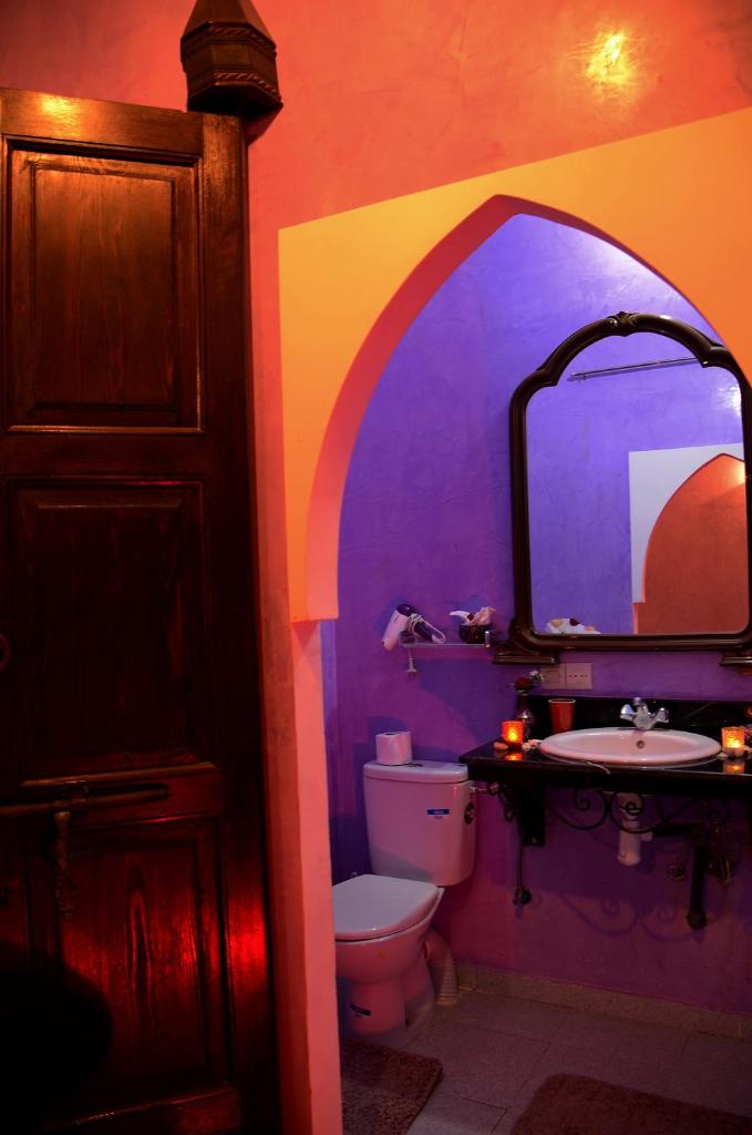 La salle de bains colorée est pourvue de toilettes et d'un lavabo. dans l'établissement Dar LEULEU, à Marrakech