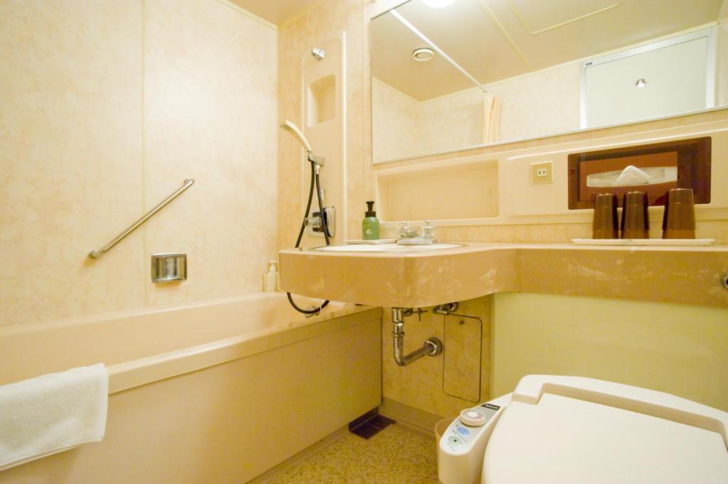 une salle de bain avec un lavabo, des toilettes et une baignoire dans l'établissement Oehonke, à Kitami
