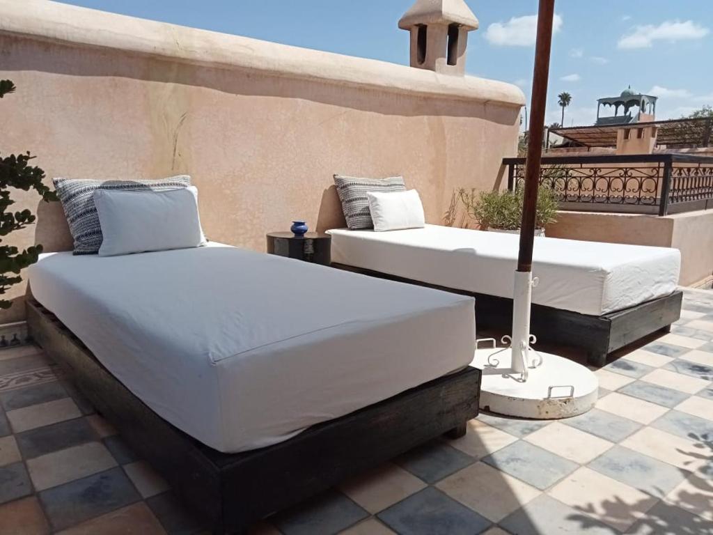 - deux lits installés au-dessus d'une terrasse dans l'établissement Dar al Sultan, à Marrakech