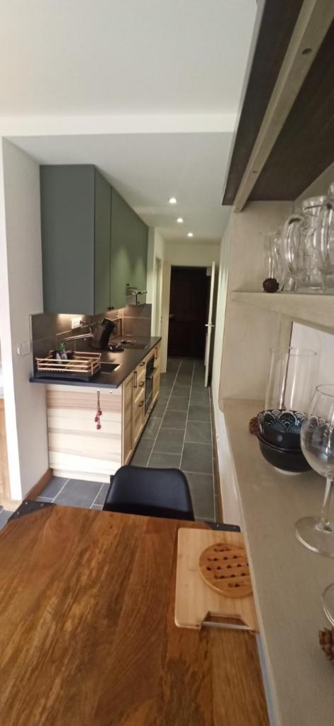 - une cuisine avec une table en bois et des verres à vin dans l'établissement LUMINEUX 30 m avec BALCON- CENTRE VILLAGE, au Monêtier-les-Bains