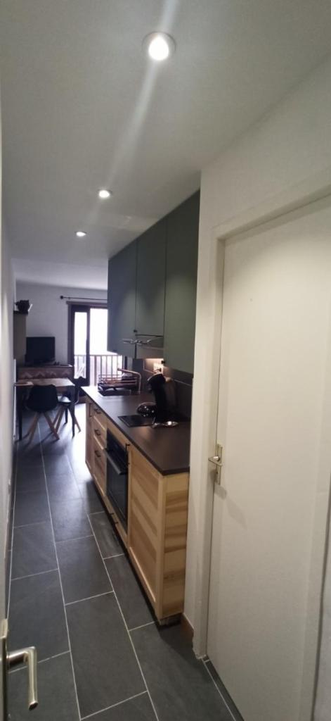 - une cuisine avec des armoires bleues et une table dans une pièce dans l'établissement LUMINEUX 30 m avec BALCON- CENTRE VILLAGE, au Monêtier-les-Bains