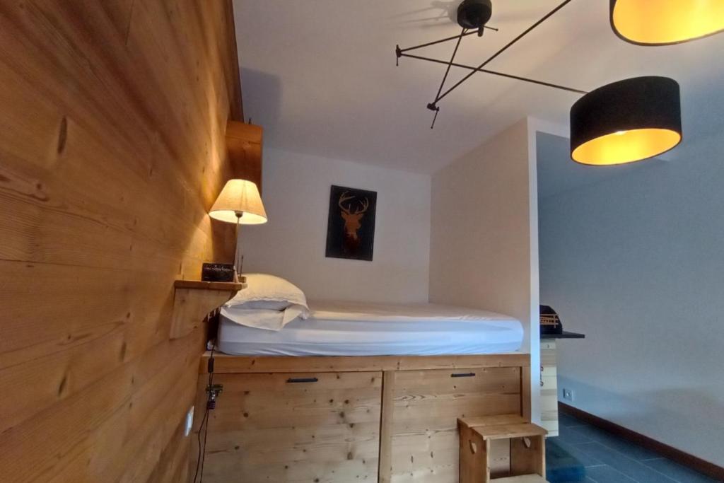 une chambre avec un lit au-dessus d'une armoire en bois dans l'établissement LUMINEUX 30 m avec BALCON- CENTRE VILLAGE, au Monêtier-les-Bains