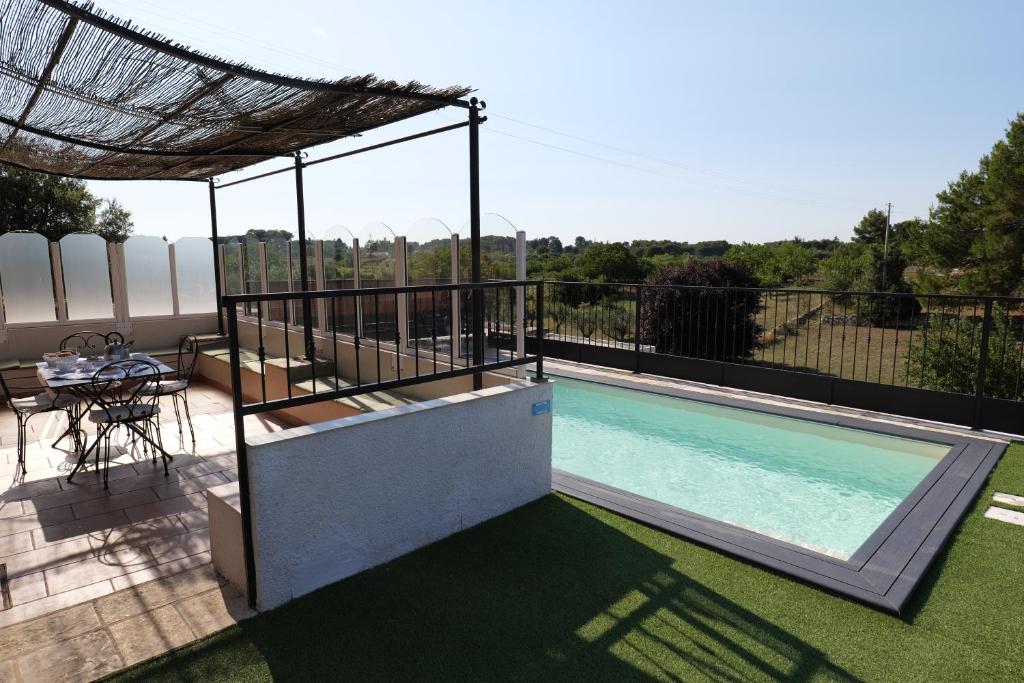 - une piscine sur une terrasse avec un toit dans l'établissement Il borgodellequerce CASA ULIVI PISCINA PRIVATA, à Martina Franca