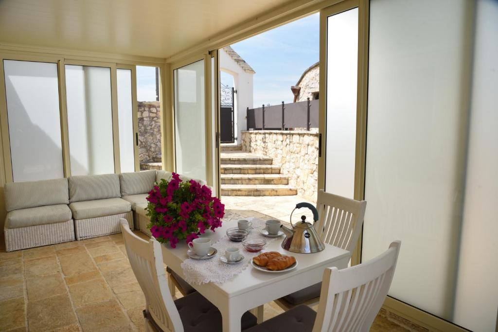 - un balcon avec une table et un service à thé dans l'établissement Trullo delle Querce Suite Private Pool, à Martina Franca