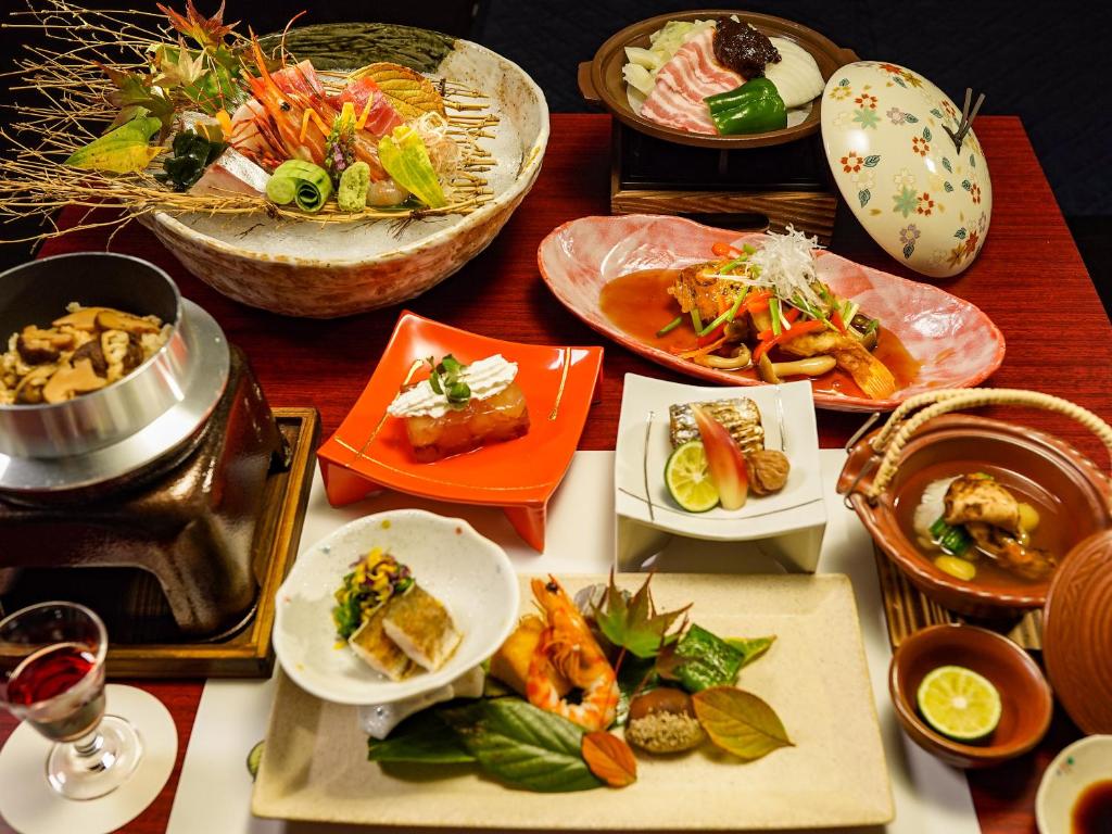 une table avec de nombreuses assiettes de nourriture dessus dans l'établissement Hakone Onsen Yuyado Yamanoshou, à Hakone
