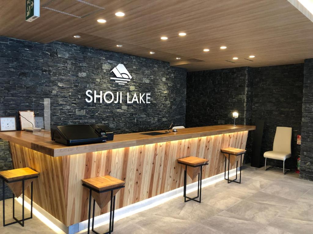 barre aitzahuake avec tabourets et panneau sur le mur dans l'établissement Shoji Lake Hotel, à Fujikawaguchiko