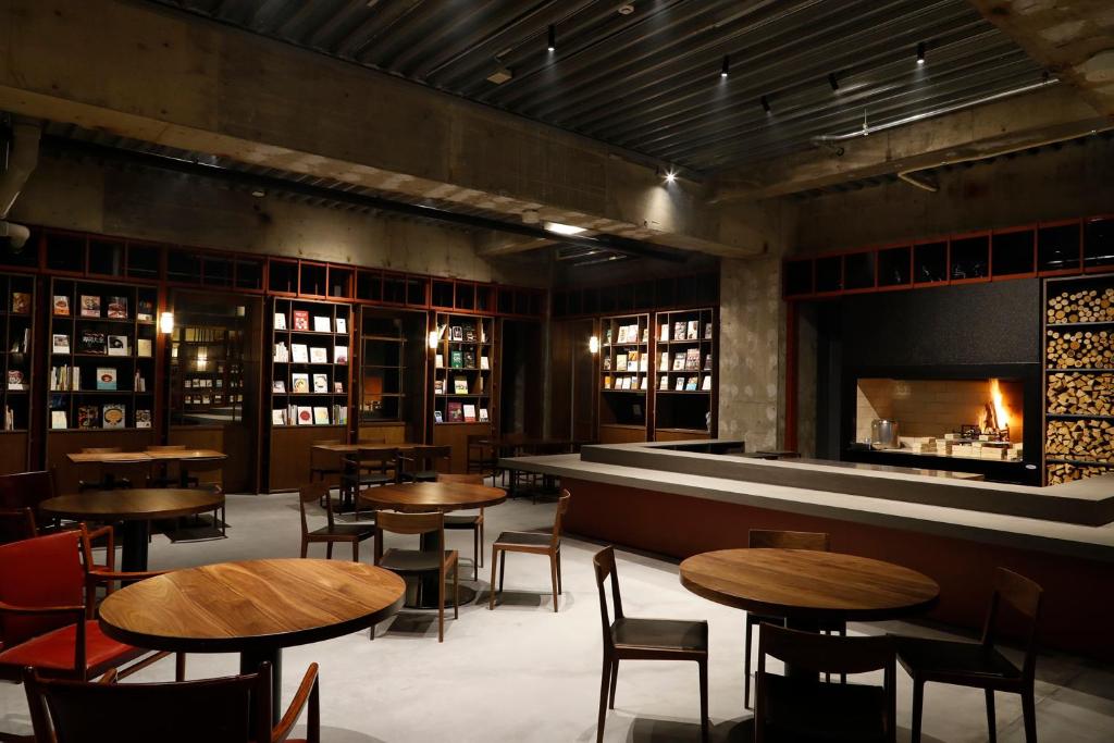 un restaurant avec des tables et des chaises et une cheminée dans l'établissement Matsumoto Jujo, à Matsumoto