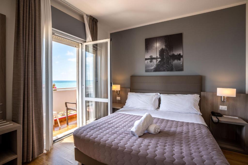 une chambre avec un lit avec vue sur l'océan dans l'établissement Hotel Loreley, à Lido di Jesolo