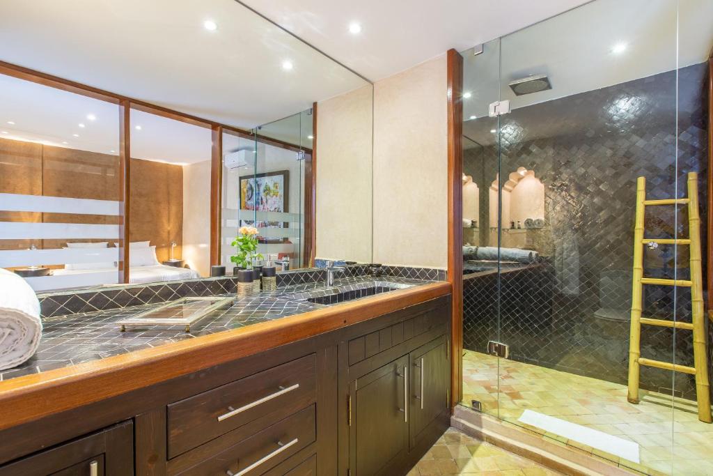 La salle de bains est pourvue d'une double vasque et d'une douche. dans l'établissement Riad Princesse Des Sables- Jaccuzzi& SPA-Breakfast, à Marrakech