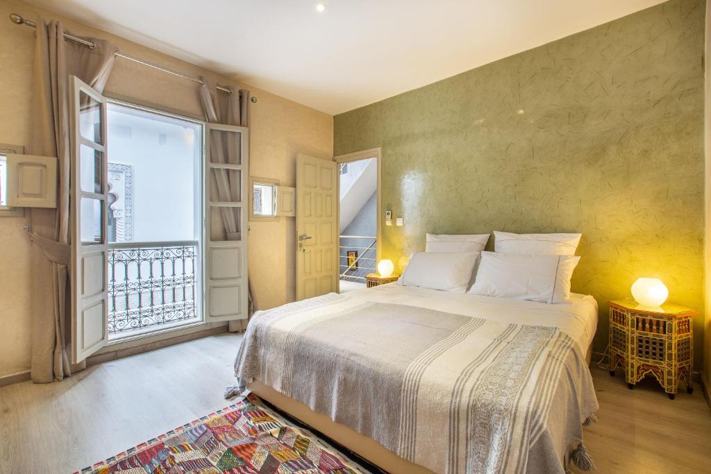 une chambre avec un grand lit et une grande fenêtre dans l'établissement Riad Princesse Des Sables- Jaccuzzi& SPA-Breakfast, à Marrakech