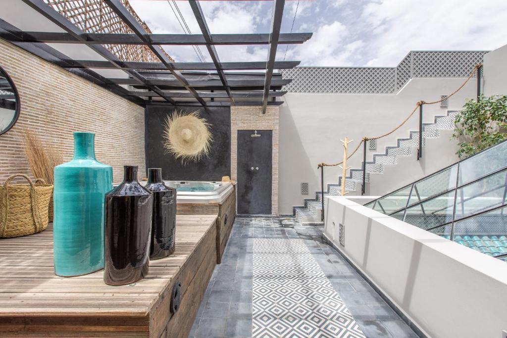une maison avec une piscine entourée de vases sur une terrasse dans l'établissement Riad Princesse Des Sables- Jaccuzzi& SPA-Breakfast, à Marrakech
