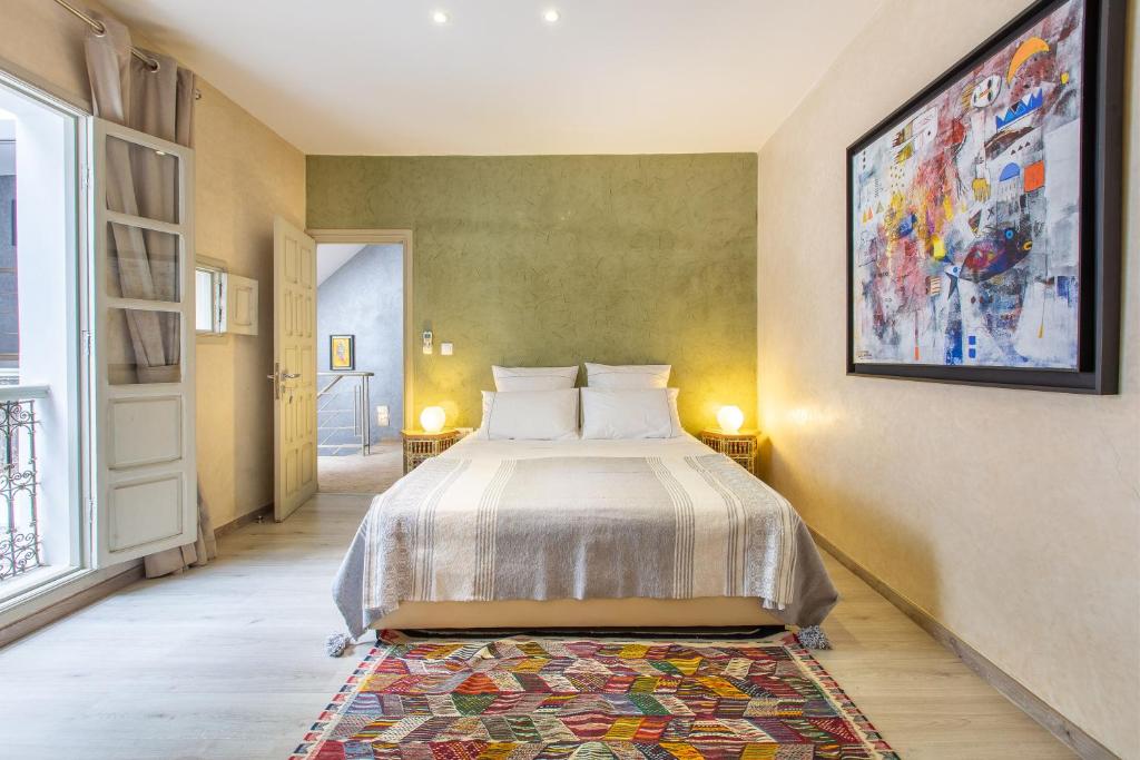 une chambre avec un lit et un tableau au mur dans l'établissement Riad Princesse Des Sables- Jaccuzzi& SPA-Breakfast, à Marrakech 23 autres photos