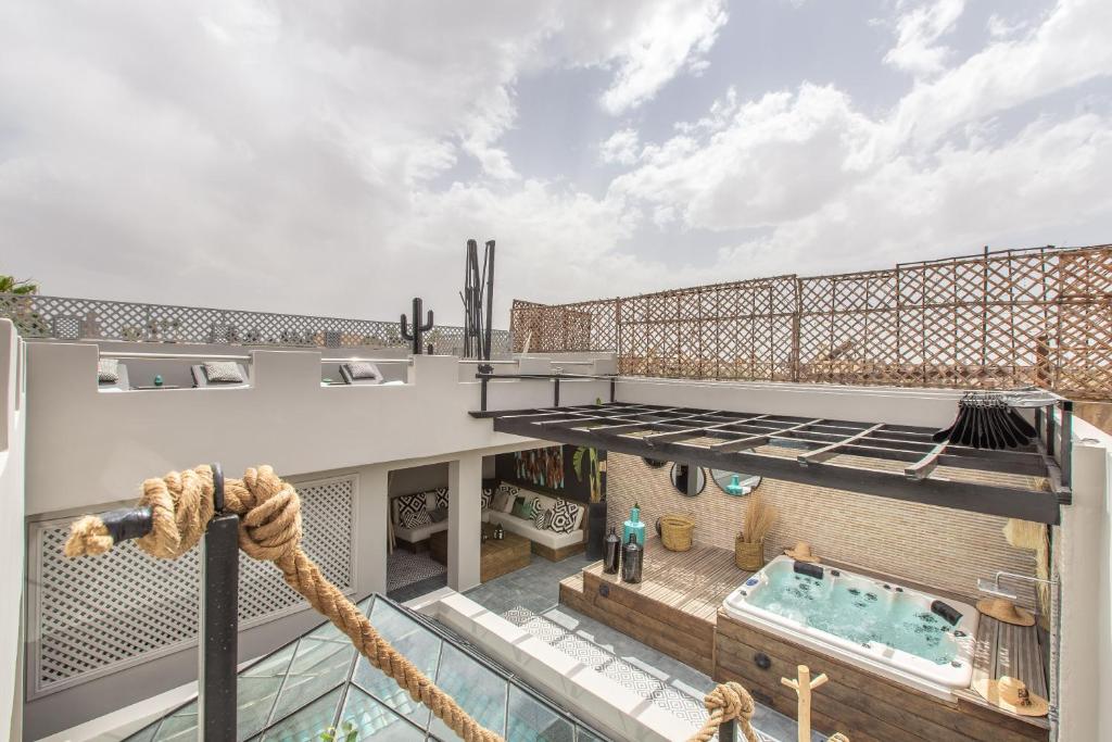 une terrasse avec une piscine dans une maison dans l'établissement Riad Princesse Des Sables- Jaccuzzi& SPA-Breakfast, à Marrakech