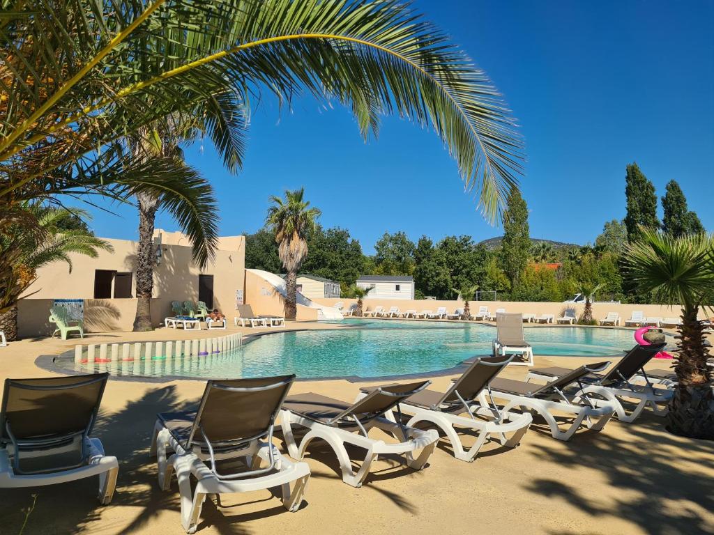 - un groupe de chaises longues à côté de la piscine dans l'établissement Camping Domaine Du Golfe De Saint Tropez, à Grimaud